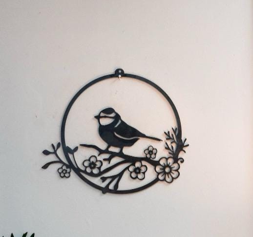 Steel wall art handing of Blue tit bird on branch with flowers displayed in a circle