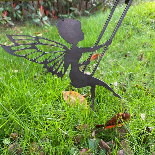 Steel garden ornament of a Fairy on a garden swing