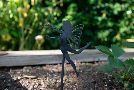 Steel Fairy with a wand, attached to a metal pole that is spiked into the garden