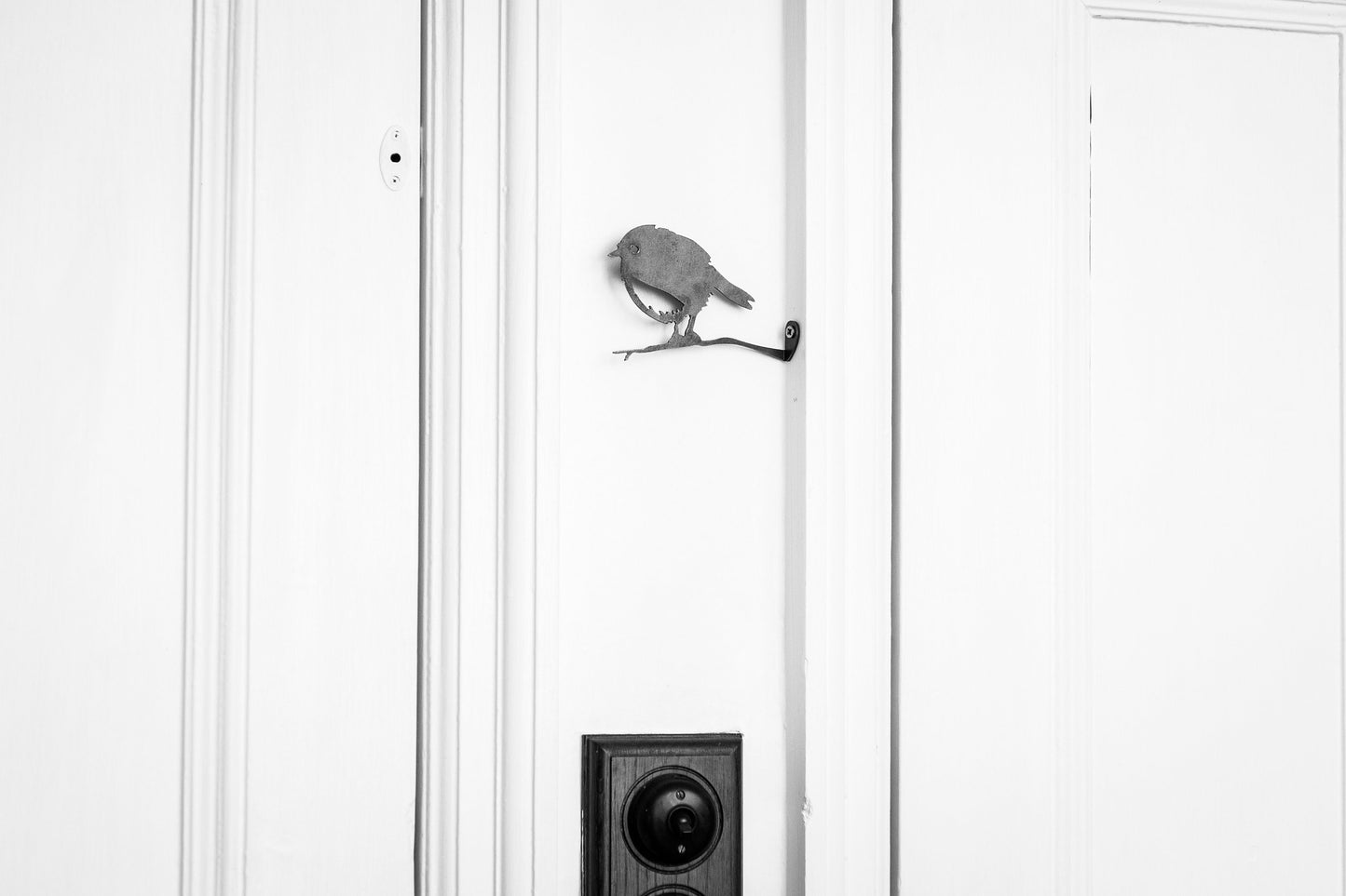 Home decor Steelrobin on a branch attahced to the side of a door frame.