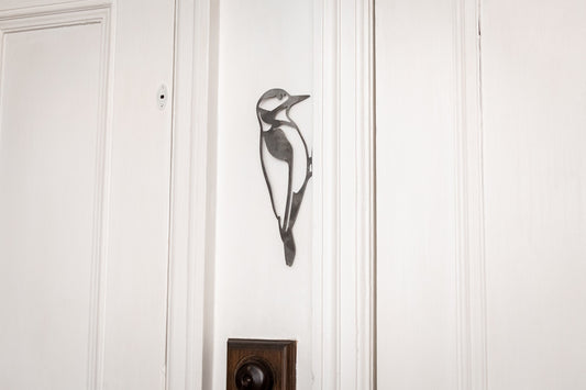 Steel Woodpecker decoration attached to a doorframe