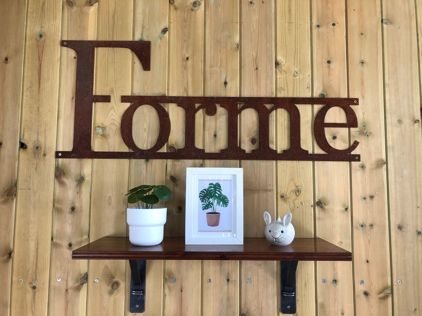 Forme Sign on a wooden background and a shelf highlighting handmade steel brackets