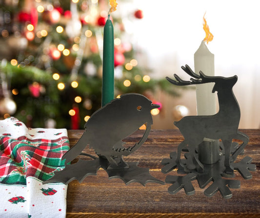 Decorative candle holders shaped like a Rpbin and a reindeer on a wooden surface with a Christmas tree in the background.